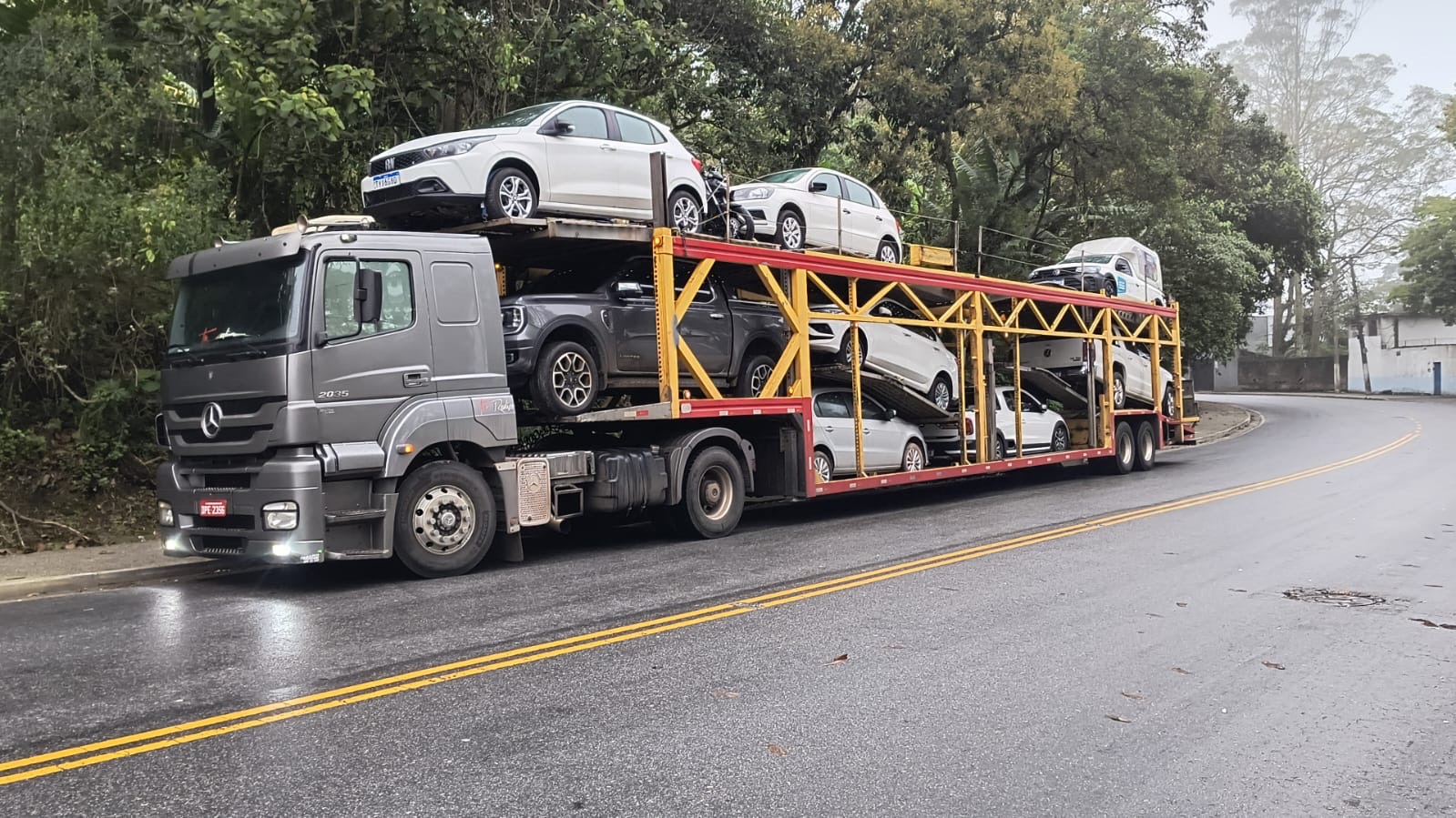 Cegonha Mercedes-Benz carregada em uma estrada molhada